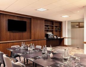 Professional meeting room with TV screen and coffee maker at the Hilton Birmingham Metropole.