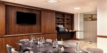 Professional meeting room with TV screen and coffee maker at the Hilton Birmingham Metropole.