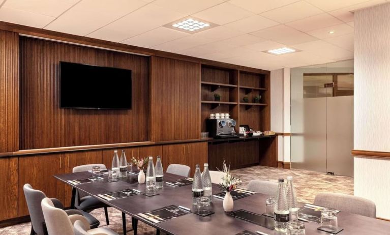 Professional meeting room with TV screen and coffee maker at the Hilton Birmingham Metropole.