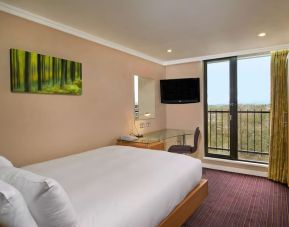 Single room with work desk, TV screen, closet and balcony at the Hilton Birmingham Metropole.