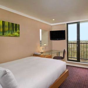 Single room with work desk, TV screen, closet and balcony at the Hilton Birmingham Metropole.