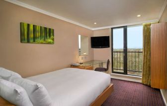 Single room with work desk, TV screen, closet and balcony at the Hilton Birmingham Metropole.