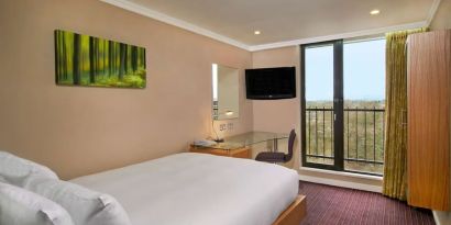 Single room with work desk, TV screen, closet and balcony at the Hilton Birmingham Metropole.