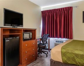 Day room with TV and fridge at Coratel Inn & Suites By Jasper River Falls.