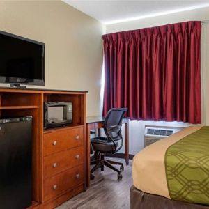 Day room with TV and fridge at Coratel Inn & Suites By Jasper River Falls.