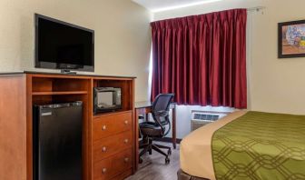 Day room with TV and fridge at Coratel Inn & Suites By Jasper River Falls.