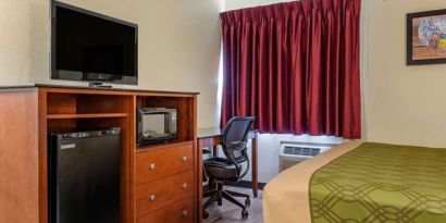 Day room with TV and fridge at Coratel Inn & Suites By Jasper River Falls.