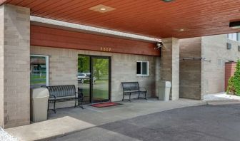 Outdoor seating and hotel entrance at Coratel Inn & Suites By Jasper River Falls.