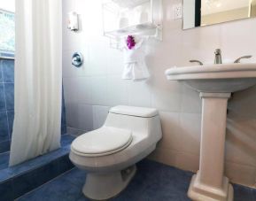 Guest bathroom with shower at Hollywood Beach Suites, A South Beach Group Hotel.