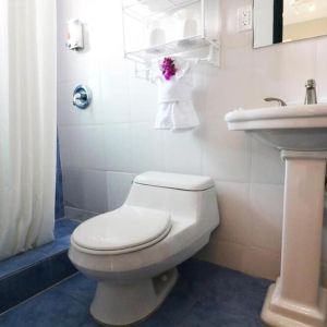 Guest bathroom with shower at Hollywood Beach Suites, A South Beach Group Hotel.