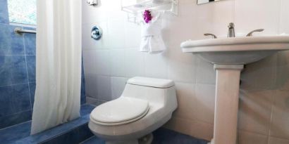 Guest bathroom with shower at Hollywood Beach Suites, A South Beach Group Hotel.