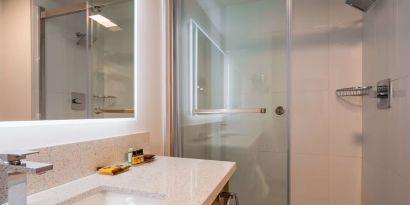 Day use guest bathroom with shower and toiletries at Executive Residency By Best Western.