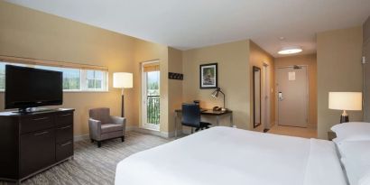 King bed with TV, terrace, workdesk and private bathroom at Hilton Whistler Resort & Spa.