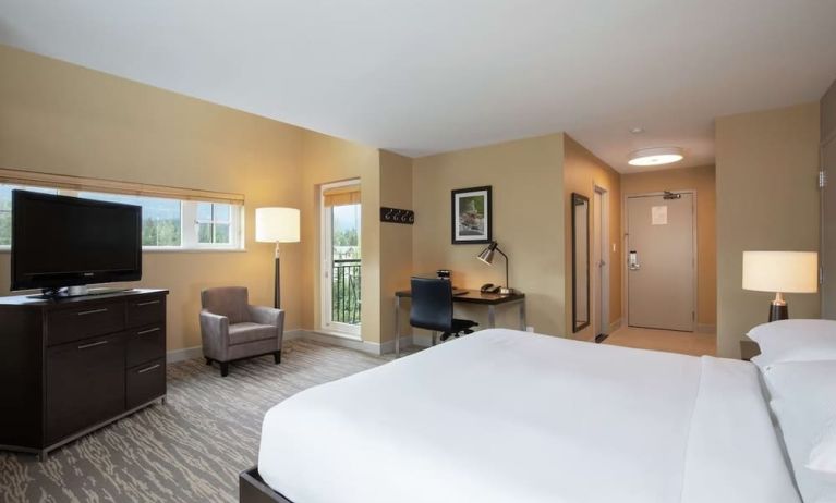 King bed with TV, terrace, workdesk and private bathroom at Hilton Whistler Resort & Spa.