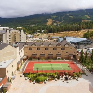 Hotel outdoor with tennis courtyard and lounge area at Hilton Whistler Resort & Spa.