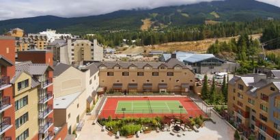 Hotel outdoor with tennis courtyard and lounge area at Hilton Whistler Resort & Spa.