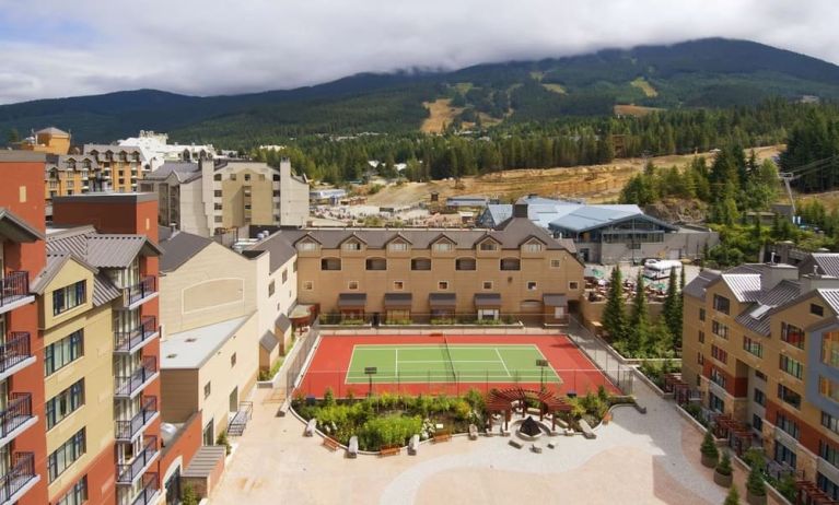 Hotel outdoor with tennis courtyard and lounge area at Hilton Whistler Resort & Spa.