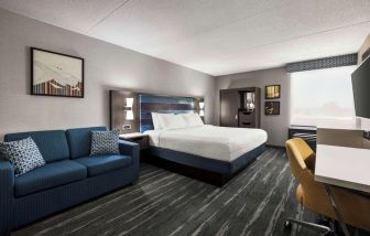 Spacious day use room with sofa and work desk at Hampton Inn Chicago O`Hare.