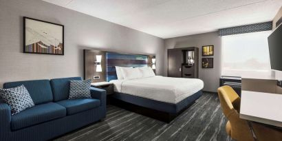 Spacious day use room with sofa and work desk at Hampton Inn Chicago O`Hare.