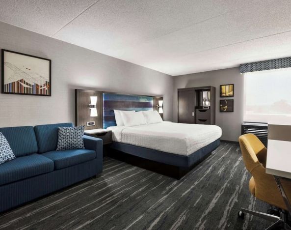 Spacious day use room with sofa and work desk at Hampton Inn Chicago O`Hare.