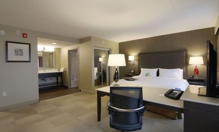 Day use room with king size bed, sofa, TV and working station at the Hampton Inn & Suites by Hilton Toronto Markham.