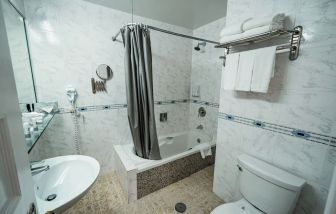 Guest bathroom with shower and tub at Congress Plaza Hotel.