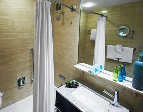 Guest bathroom with shower and tub at Miami International Airport Hotel.