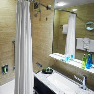 Guest bathroom with shower and tub at Miami International Airport Hotel.