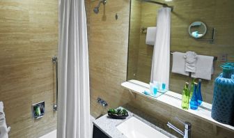 Guest bathroom with shower and tub at Miami International Airport Hotel.