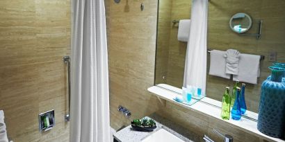 Guest bathroom with shower and tub at Miami International Airport Hotel.