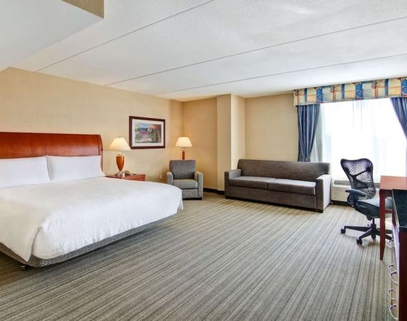 Day use room with TV, work desk, and sofa at Hilton Garden Inn Toronto/Burlington.