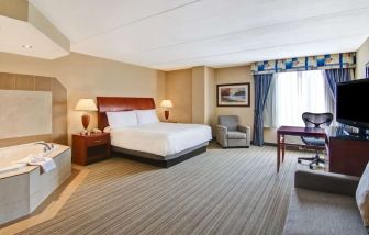 Day use room with TV, work desk, sofa and tub at Hilton Garden Inn Toronto/Burlington.