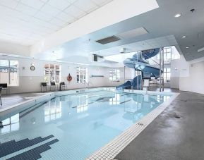 Indoor pool with lounge chairs at Holiday Inn Express & Suites Airport-Calgary.