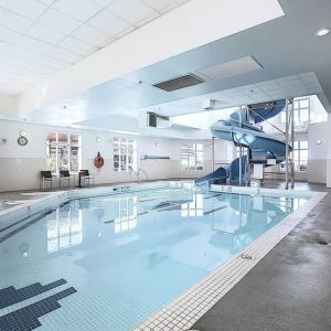 Indoor pool with lounge chairs at Holiday Inn Express & Suites Airport-Calgary.