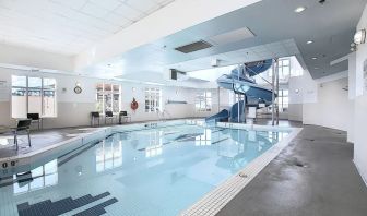 Indoor pool with lounge chairs at Holiday Inn Express & Suites Airport-Calgary.