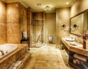 Private guest bathroom with shower and tub at Hotel Brossard.