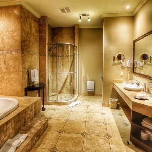 Private guest bathroom with shower and tub at Hotel Brossard.