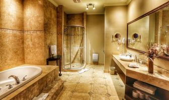 Private guest bathroom with shower and tub at Hotel Brossard.