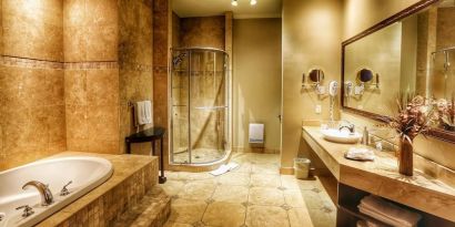 Private guest bathroom with shower and tub at Hotel Brossard.