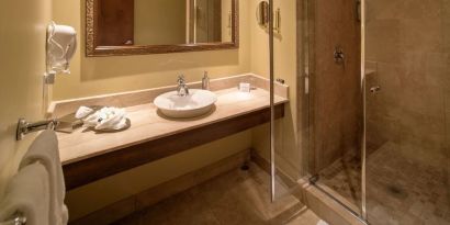 Private guest bathroom with shower and toiletries at Hotel Brossard.