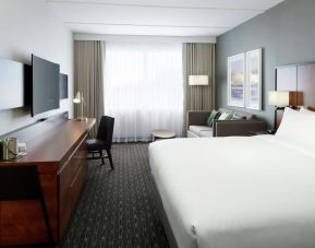 Standard day use room with work desk, TV, lounge area and private bathroom at DoubleTree By Hilton Montreal Airport.