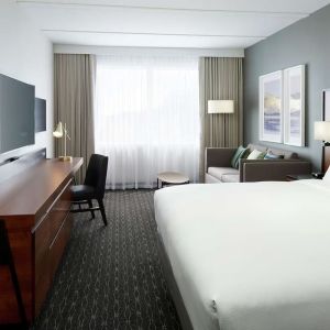 Standard day use room with work desk, TV, lounge area and private bathroom at DoubleTree By Hilton Montreal Airport.