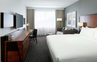 Standard day use room with work desk, TV, lounge area and private bathroom at DoubleTree By Hilton Montreal Airport.