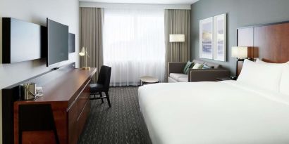 Standard day use room with work desk, TV, lounge area and private bathroom at DoubleTree By Hilton Montreal Airport.