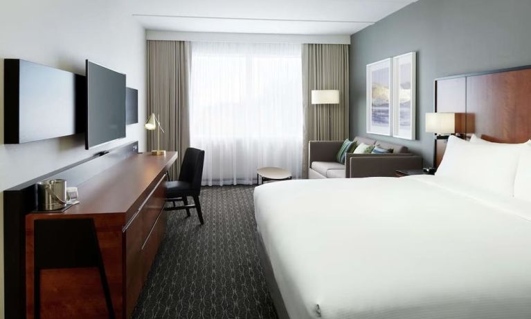 Standard day use room with work desk, TV, lounge area and private bathroom at DoubleTree By Hilton Montreal Airport.