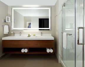 Private guest bathroom with shower and toiletries at DoubleTree By Hilton Montreal Airport.