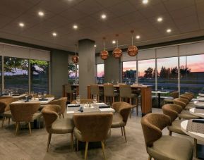 Restaurant area with comfortable seating at the Embassy Suites by Hilton Montreal Airport.