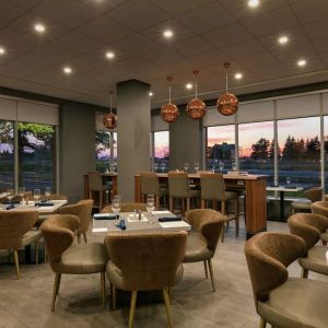 Restaurant area with comfortable seating at the Embassy Suites by Hilton Montreal Airport.