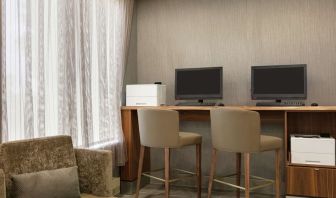 Business center with computers, printers and comfortable seating at the Embassy Suites by Hilton Montreal Airport.