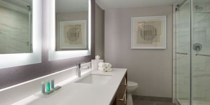 Guest bathroom with shower at Courtyard By Marriott Kitchener.